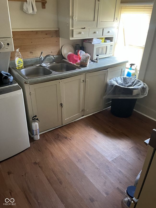 laundry area featuring wood finished floors and water heater | Image 12