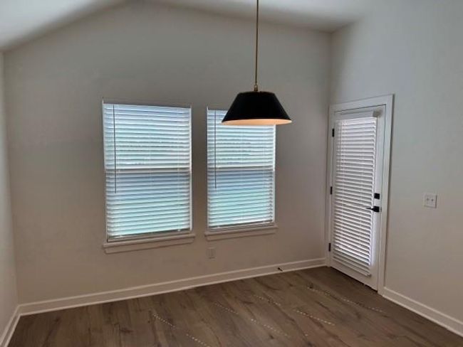 Unfurnished dining area with dark wood-style floors and baseboards | Image 17