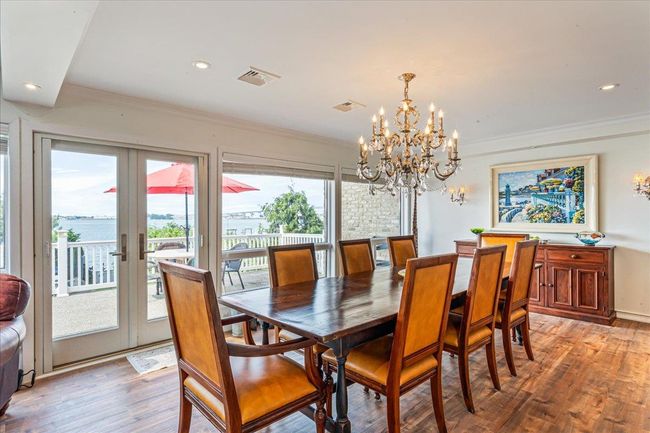 Dining area featuring light wood-type flooring, crown molding, a chandelier, french doors, and recessed lighting | Image 10