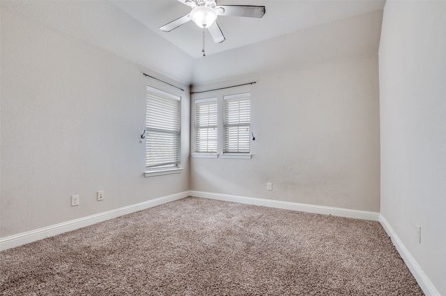 Spare room featuring carpet, lofted ceiling, and a ceiling fan | Image 12