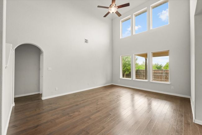 Living room with ceiling fan, a high ceiling, and a wall of windows | Image 10