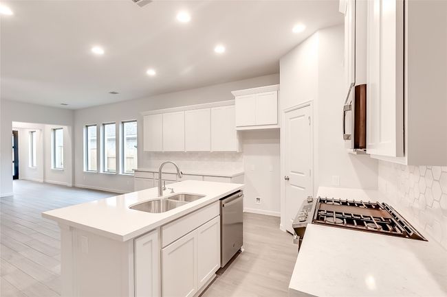 Kitchen with appliances with stainless steel finishes, a sink, decorative backsplash, recessed lighting, and a kitchen island with sink | Image 12