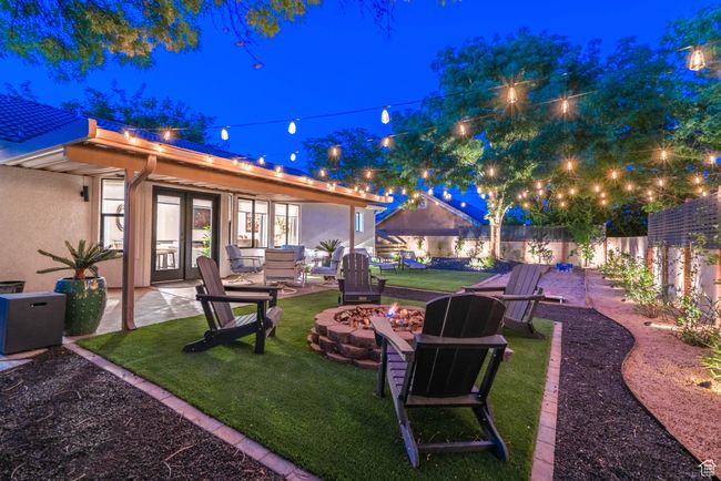 Yard at twilight featuring an outdoor living space with a fire pit, french doors, and a patio | Image 14