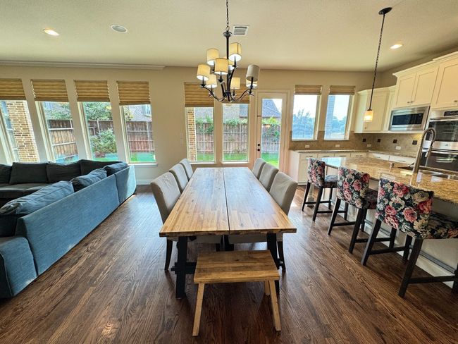 Dining area with a chandelier, healthy amount of natural light, dark wood-style flooring, and recessed lighting | Image 5