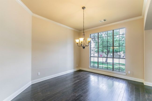 Unfurnished room featuring ornamental molding, a notable chandelier, and a large window | Image 15