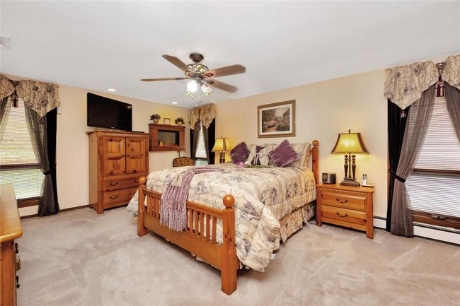 Bedroom featuring track lighting, carpet flooring, and baseboard heating | Image 23