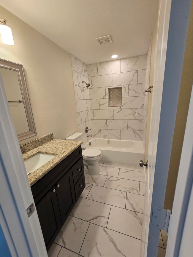 Bathroom featuring marble finish flooring, toilet, vanity, shower / bath combination, and recessed lighting | Image 27