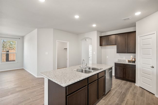 Kitchen with stainless steel dishwasher, visible vents, a sink, and wood finish floors | Image 26
