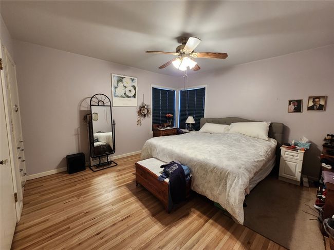 Bedroom with a ceiling fan, light wood-style flooring, and baseboards | Image 25