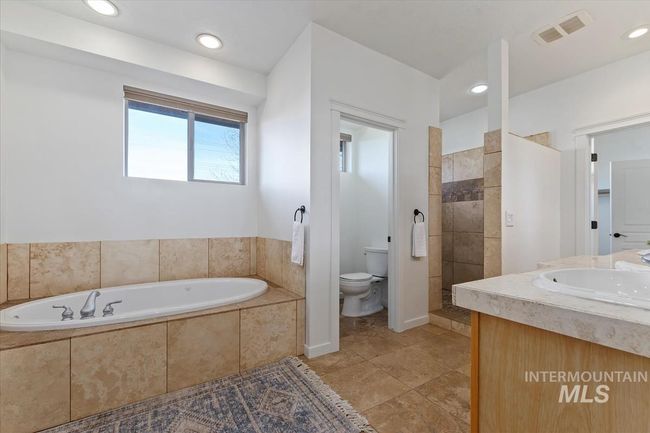 Bathroom with a garden tub, recessed lighting, vanity, a walk in shower, and tile patterned flooring | Image 33