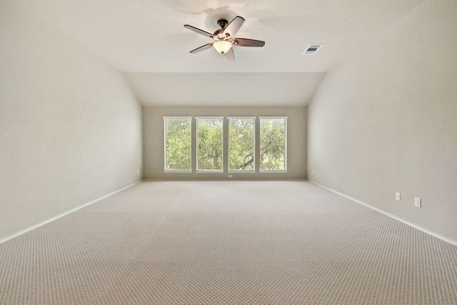 Unfurnished room with light colored carpet, ceiling fan, and vaulted ceiling | Image 19