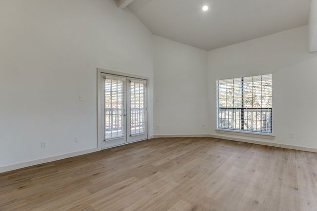 Empty room featuring high vaulted ceiling, beam ceiling, french doors, and light wood-type flooring | Image 11