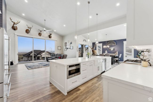 Kitchen featuring stainless steel dishwasher, white cabinets, open floor plan, recessed lighting, and vaulted ceiling | Image 50