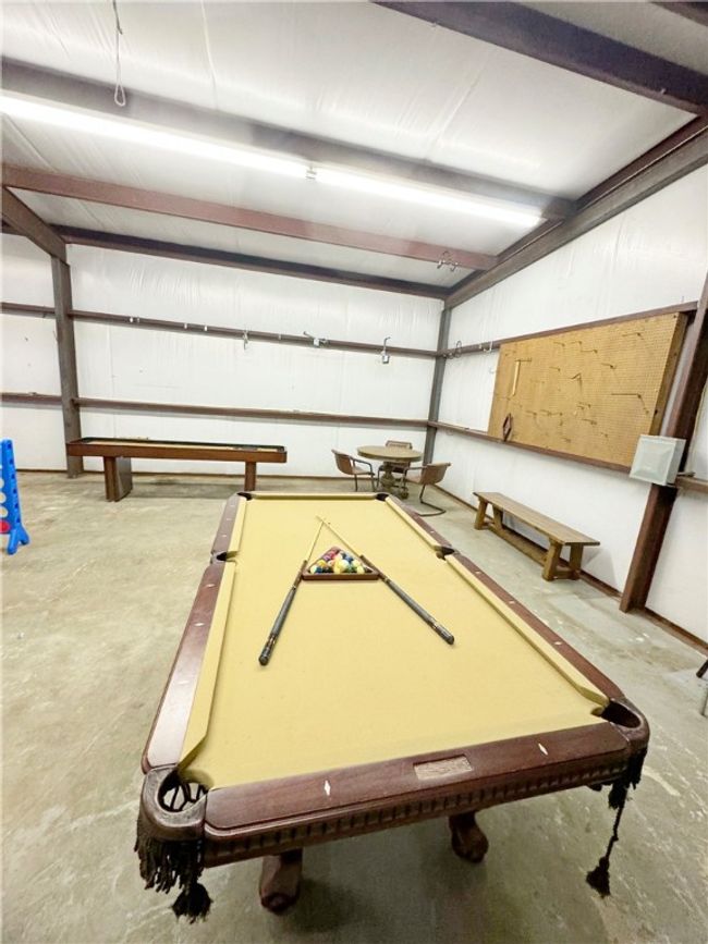 Playroom featuring pool table and unfinished concrete floors | Image 18