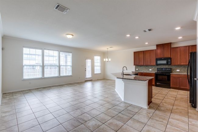 Kitchen with a sink, visible vents, black appliances, and a chandelier | Image 8