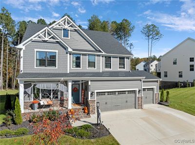 Craftsman-style home with a porch, a front lawn, and a garage | Image 1