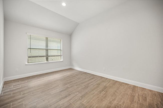Spare room featuring light wood-type flooring, vaulted ceiling, and recessed lighting | Image 22