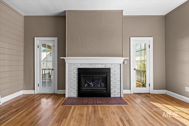 Unfurnished living room with wood finished floors and a fireplace | Image 20