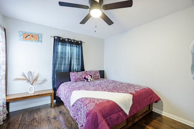 Bedroom with baseboards, ceiling fan, and wood finished floors | Image 22
