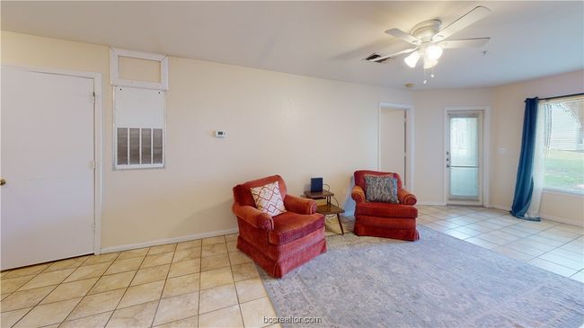 Living area featuring light tile patterned floors and ceiling fan | Image 5