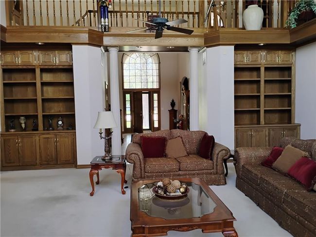 Carpeted living room featuring decorative columns and ceiling fan | Image 21