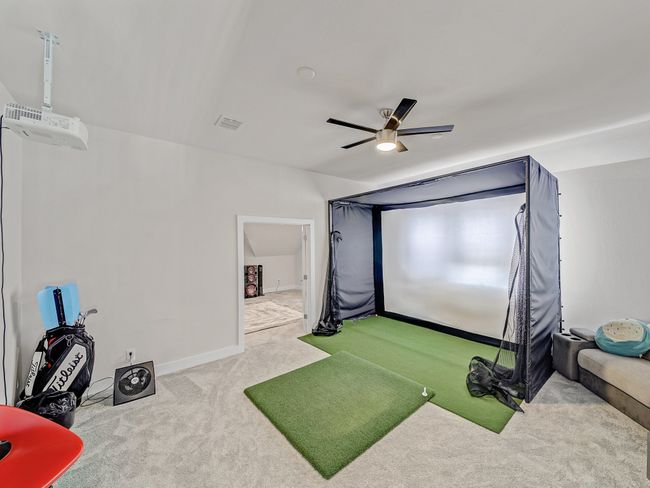 Recreation room with golf simulator, carpet flooring, and a ceiling fan | Image 24