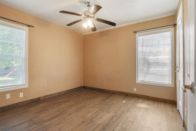 Spare room featuring a wealth of natural light, baseboards, and wood finished floors | Image 10