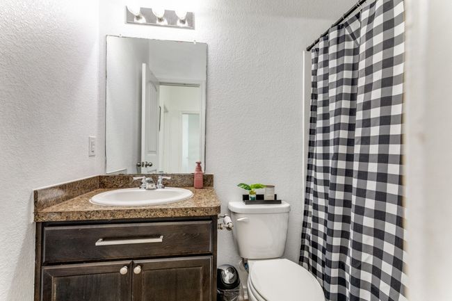 Full bathroom featuring a textured wall, vanity, and curtained shower | Image 32