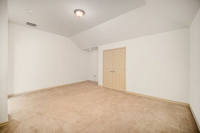 Unfurnished room with lofted ceiling, light colored carpet, baseboards, and a smoke detector | Image 23