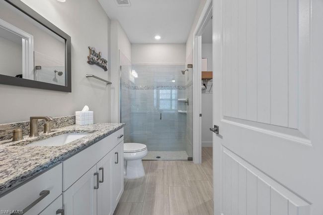 Bathroom featuring visible vents, toilet, a stall shower, and vanity | Image 10
