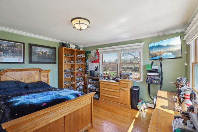Bedroom featuring ornamental molding, light wood finished floors, and a baseboard heating unit | Image 19
