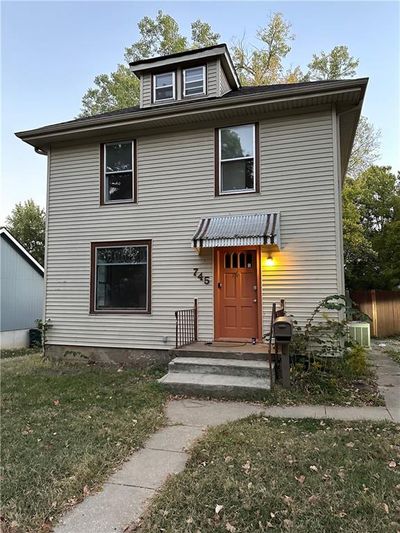 View of front property with cooling unit and a front lawn | Image 1