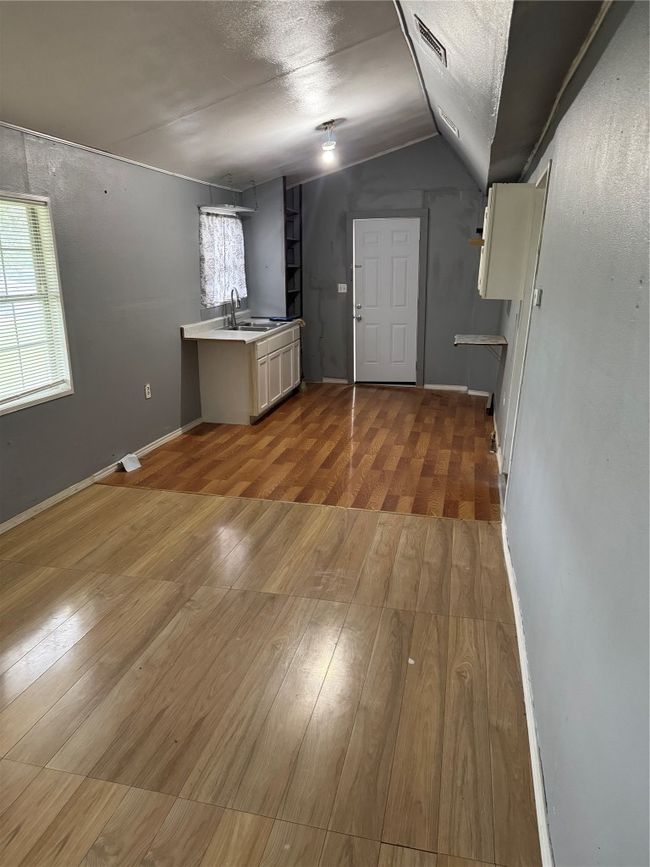 Below grade area featuring wood finished floors, a sink, and visible vents | Image 6