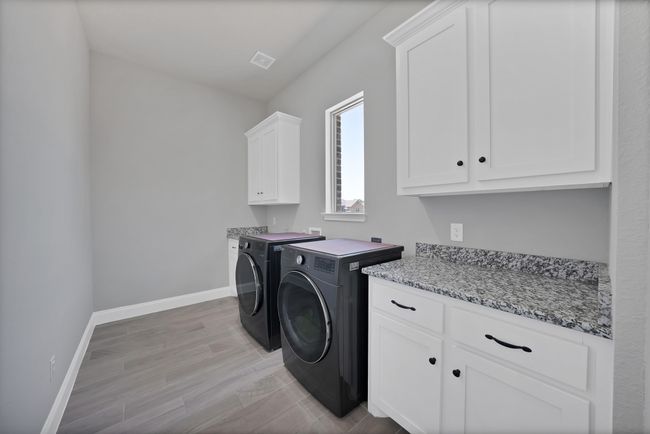 Laundry room with cabinet space, washing machine and dryer, and baseboards | Image 17