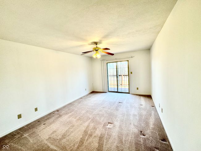 carpeted spare room featuring baseboards, a textured ceiling, and a ceiling fan | Image 11