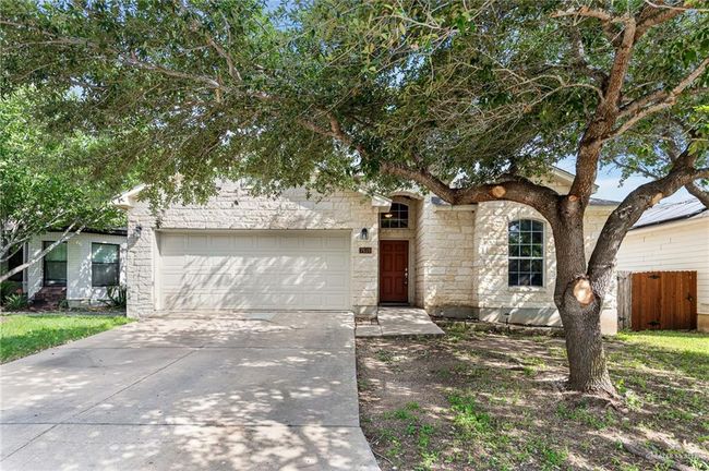 View of front of property featuring an attached garage, stone siding, and concrete driveway | Image 4