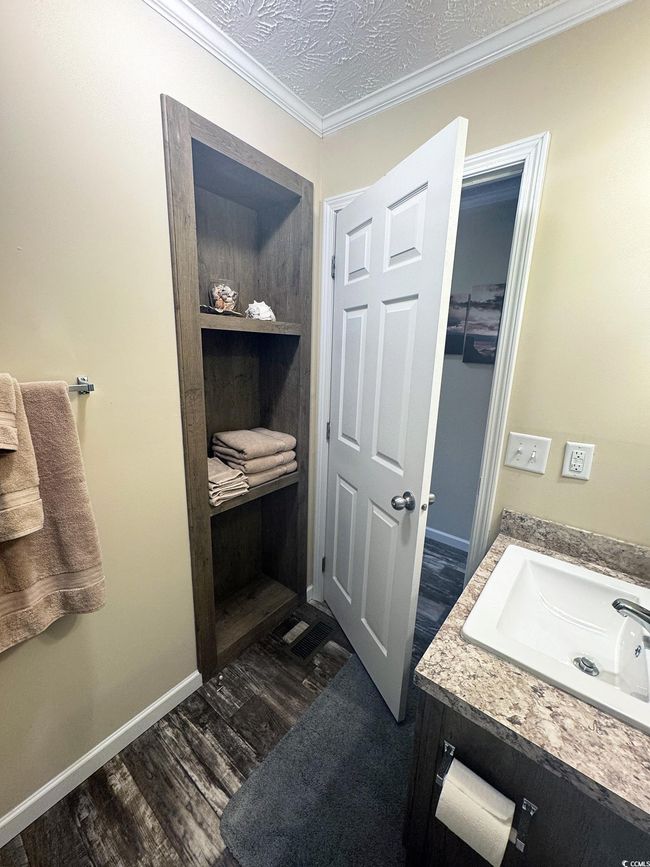 Bathroom with vanity, crown molding, and wood finished floors | Image 29