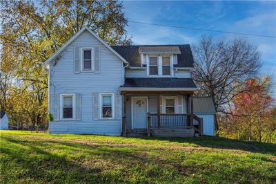 View of front of property with covered porch and a front yard | Image 1