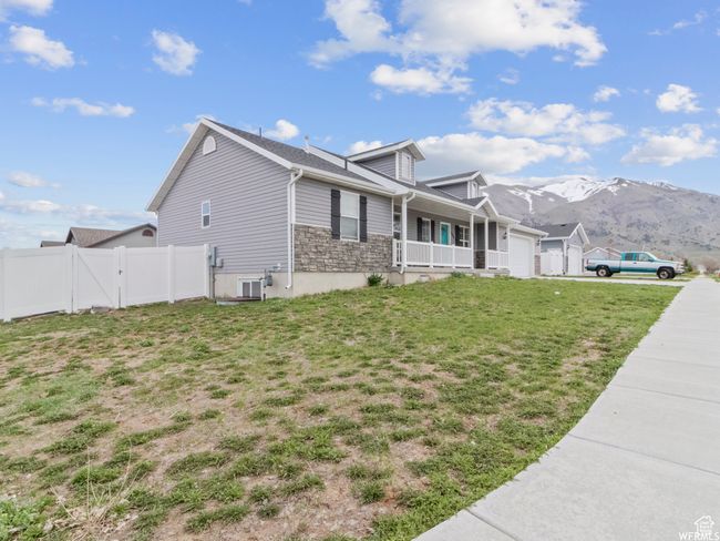 View of side of home featuring an attached garage, a porch, and a mountain view | Image 25