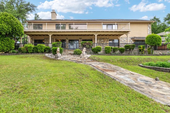 Rear view of house featuring stone siding and fence private yard | Image 34