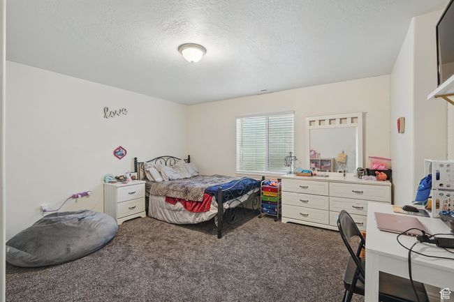Bedroom with carpet floors, visible vents, and a textured ceiling | Image 33
