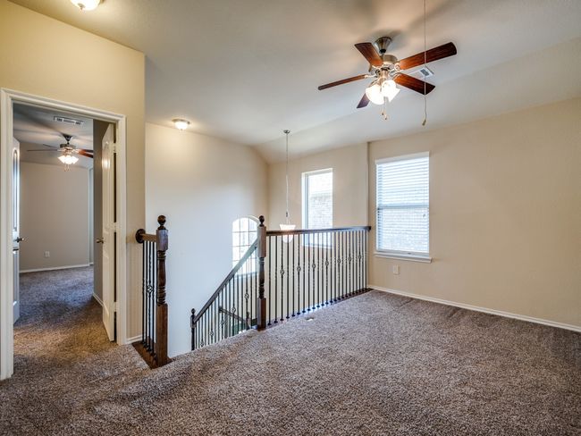 Empty room with baseboards, vaulted ceiling, visible vents, and dark carpet | Image 7