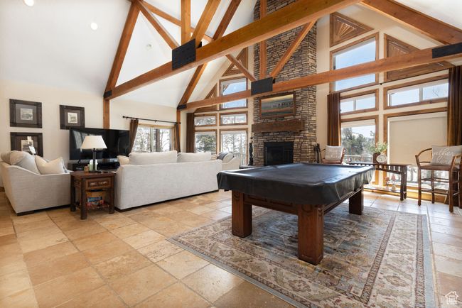 Rec room featuring beamed ceiling, high vaulted ceiling, pool table, and stone tile flooring | Image 25