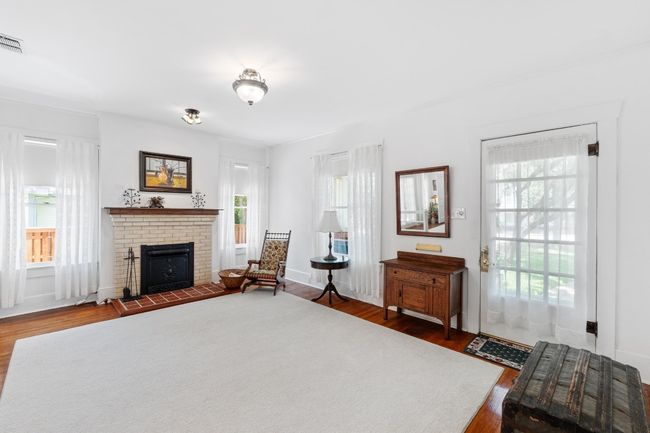living room with fireplace that is mock and wood floors | Image 6