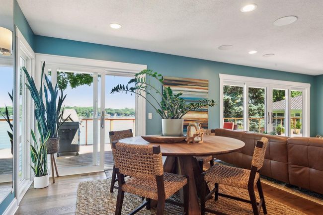 Main level living area is light and bright thanks to generous use of in-ceiling lighting and the wall of glass! There are in-ceiling speakers for TV surround sound or pipe in music to help set the mood. | Image 11