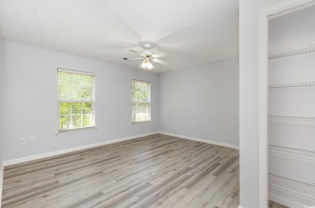 Spare room featuring baseboards, light wood-type flooring, and a ceiling fan | Image 14