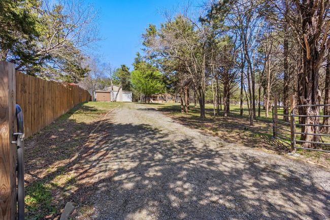 View of street with driveway, a gate, and a gated entry | Image 5
