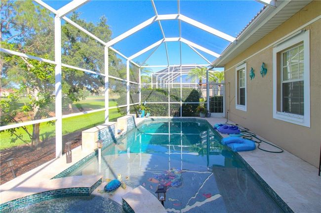 View of swimming pool featuring a patio, a lanai, and a lawn | Image 10