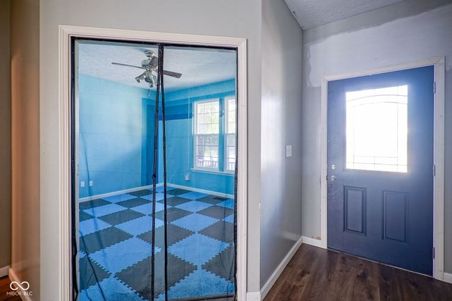 foyer featuring dark wood-type flooring, a textured ceiling, and ceiling fan | Image 6