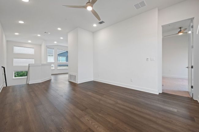 Unfurnished living room featuring ceiling fan, dark wood-style flooring, and recessed lighting | Image 4